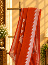 A burnt orange tussar georgette saree with bold floral bouquets woven all over in silver zari
