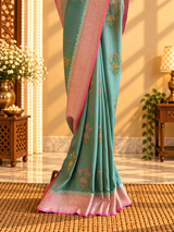 A shaded green muga georgette saree with meenakari floral bootas and a contrast pink kanni
