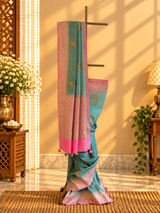 A shaded green muga georgette saree with meenakari floral bootas and a contrast pink kanni