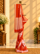 A burnt orange tussar georgette saree with bold floral bouquets woven all over in silver zari