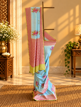 A fresh powder blue muga georgette saree with meenakari floral bootas dismissed off with a pink border and a fresh lime green kanni