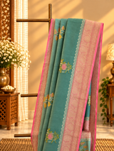 A shaded green muga georgette saree with meenakari floral bootas and a contrast pink kanni