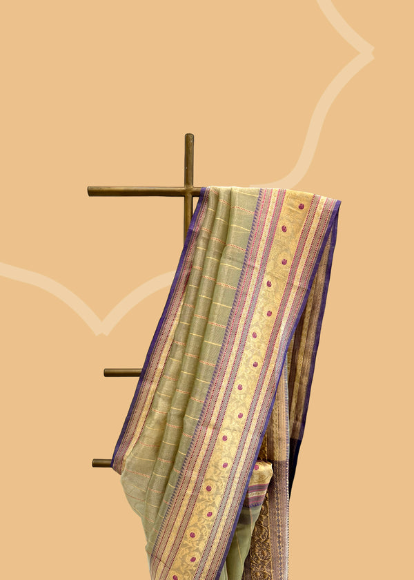 This benarasi handwoven cream saree features subtle gold bootis and a champagne shot color, complemented by a bright blue kanni and pallu. perfect for summer wedddings. Shop the best collection of authentic, handwoven, pure benarasi sarees with Roliana New Delhi