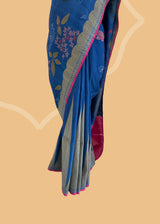 An electric blue Tussar Georgette saree by Roliana. Intricately handwoven with a beautiful contrast pink brocade blouse. Perfect for wedding and trousseau saree Shop the best collection of authentic, handwoven, pure benarasi sarees with Roliana New Delhi