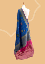 An electric blue Tussar Georgette saree by Roliana. Intricately handwoven with a beautiful contrast pink brocade blouse. Perfect for wedding and trousseau saree Shop the best collection of authentic, handwoven, pure benarasi sarees with Roliana New Delhi