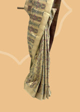 This unique and stylish Ivory & Moss Green Tanchoi Silk Benarasi Saree from Roliana is crafted with an exquisite combination of tanchoi weave and delicate, pink bunches of small flowers.