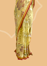 A lemon yellow khaddi Georgette saree with upada floral bootas all over which have detailed hand painted patterns all over and a contrast red kanni . Shop the best collection of authentic, handwoven, pure benarasi sarees with Roliana New Delhi