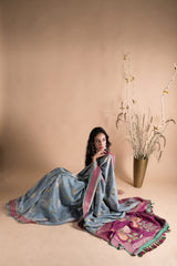 Grey saree with silver gold jaal of floral meenakari, offset with a wine border and pallu, and finished with a bright blue kanni. Shop the best collection of authentic, handwoven, pure benarasi sarees with Roliana New Delhi