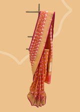a traditional peach pink shot saree in silk with Sona roopa zari bootis and a chevron zari border and pallu. A pure Banarasi wedding Sari Shop the best collection of authentic, handwoven, pure benarasi sarees with Roliana New Delhi