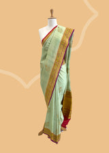 A patina green tussar Georgette saree with meenakari guldasta of flowers and a meenakari border and pallu.. A pure Banarasi Sari Shop the best collection of authentic, handwoven, pure benarasi sarees with Roliana New Delhi