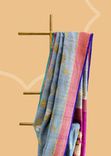 Grey saree with silver gold jaal of floral meenakari, offset with a wine border and pallu, and finished with a bright blue kanni. Shop the best collection of authentic, handwoven, pure benarasi sarees with Roliana New Delhi