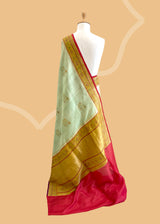 A patina green tussar Georgette saree with meenakari guldasta of flowers and a meenakari border and pallu.. A pure Banarasi Sari Shop the best collection of authentic, handwoven, pure benarasi sarees with Roliana New Delhi