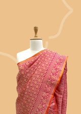 Pink silk saree in floral brocade weave with all over motifs and ornamental pallu with a delightful orange contrast kanni. pure Banarasi sari. Shop the best collection of authentic, handwoven, pure benarasi sarees with Roliana New Delhi