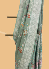 Sage green tussar georgette saree with a colourful meenakari jaal and silver zari bootis and border. Shop the best collection of authentic, handwoven, pure benarasi sarees with Roliana New Delhi