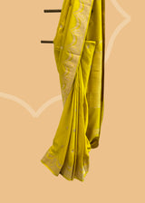 A lime green soft silk saree with small zari bootis all over and a beautiful trellis border with scallops and flowers.. A pure Banarasi Sari Shop the best collection of authentic, handwoven, pure benarasi sarees with Roliana New Delhi