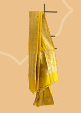 A mustard yellow saree with delicate woven flowers and border in contrast meenakari colours. A pure Banarasi Sari Shop the best collection of authentic, handwoven, pure benarasi sarees with Roliana New Delhi