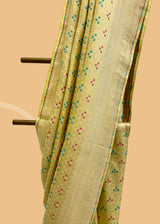 A cream yellow silk saree with brocade pyramid weave interspersed with pale yellow and firozi detailed flowers and a geometric pallu and border. A pure Banarasi wedding Sari Shop the best collection of authentic, handwoven, pure benarasi sarees with Roliana New Delhi