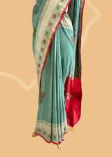 A patina green tussar Georgette saree with meenakari guldasta of flowers and a meenakari border and pallu.. A pure Banarasi wedding Sari Shop the best collection of authentic, handwoven, pure benarasi sarees with Roliana New Delhi