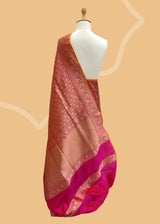Pink silk saree in floral brocade weave with all over motifs and ornamental pallu with a delightful orange contrast kanni. pure Banarasi sari. Shop the best collection of authentic, handwoven, pure benarasi sarees with Roliana New Delhi
