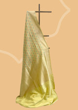 A cream yellow silk saree with brocade pyramid weave interspersed with pale yellow and firozi detailed flowers and a geometric pallu and border. A pure Banarasi wedding Sari Shop the best collection of authentic, handwoven, pure benarasi sarees with Roliana New Delhi