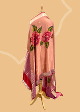 Pure silk benarasi dupatta in salmon pink with handpainted flowers by Roliana Weaves. Shop the best of Banarasi sarees, dupattas and lehengas at Roliana New Delhi