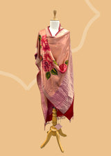 Pure silk benarasi dupatta in salmon pink with handpainted flowers by Roliana Weaves. Shop the best of Banarasi sarees, dupattas and lehengas at Roliana New Delhi