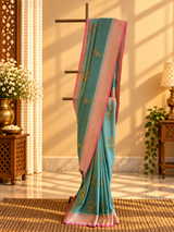 A shaded green muga georgette saree with meenakari floral bootas and a contrast pink kanni