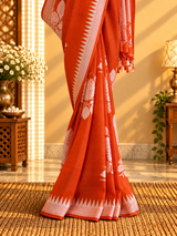 A burnt orange tussar georgette saree with bold floral bouquets woven all over in silver zari