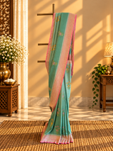 A shaded green muga georgette saree with meenakari floral bootas and a contrast pink kanni