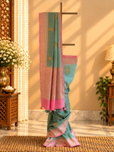 A shaded green muga georgette saree with meenakari floral bootas and a contrast pink kanni