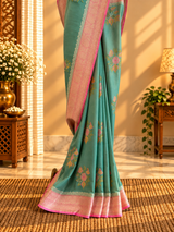 A shaded green muga georgette saree with meenakari floral bootas and a contrast pink kanni