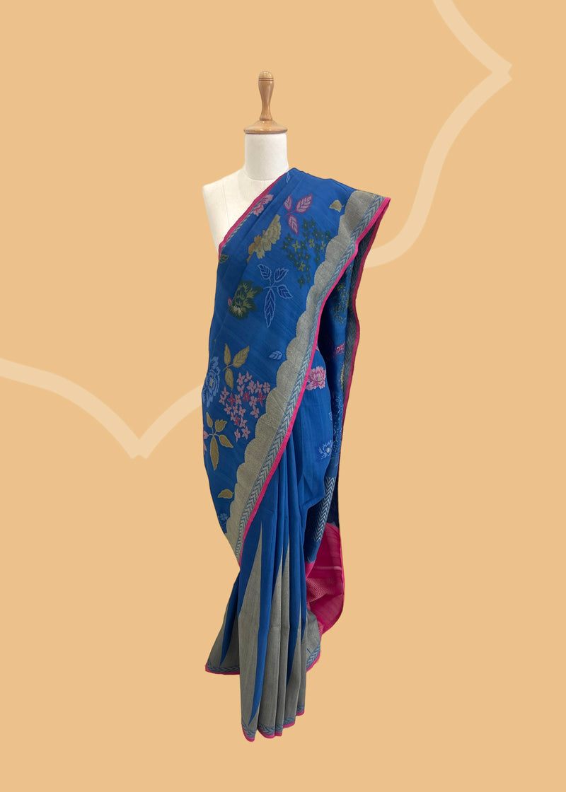 An electric blue Tussar Georgette saree by Roliana. Intricately handwoven with a beautiful contrast pink brocade blouse. Perfect for wedding and trousseau saree Shop the best collection of authentic, handwoven, pure benarasi sarees with Roliana New Delhi
