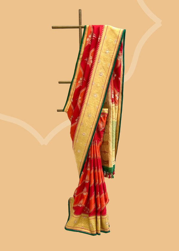 A pure ektaara silk weave saree with hand painted lehar jaal work in sunset red shades with a beautiful gold border and a bright emerald green contrast kanni . Shop the best collection of authentic, handwoven, pure benarasi sarees with Roliana New Delhi