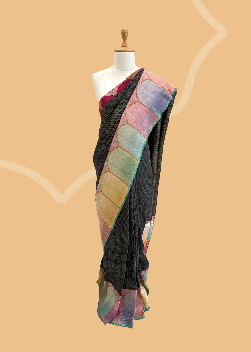 A charcoal grey chevron weave saree with handshaded mehraab border motifs. Shop the best collection of authentic, handwoven, pure benarasi sarees with Roliana New Delhi