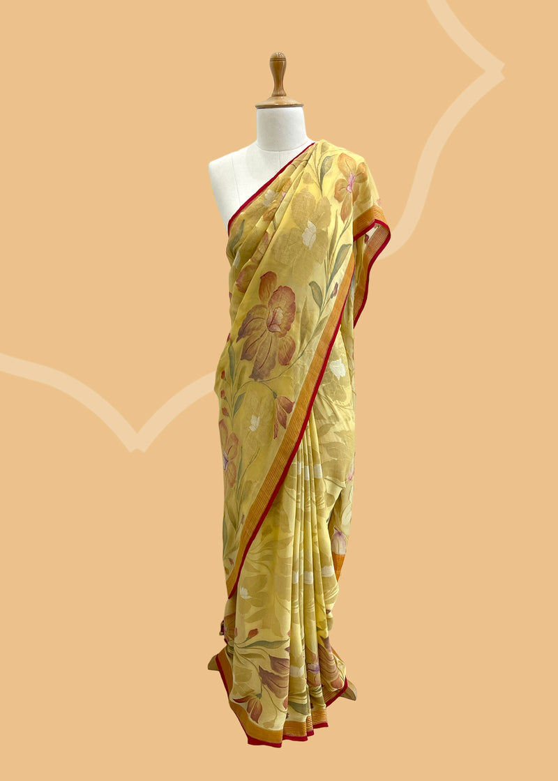 A lemon yellow khaddi Georgette saree with upada floral bootas all over which have detailed hand painted patterns all over and a contrast red kanni . Shop the best collection of authentic, handwoven, pure benarasi sarees with Roliana New Delhi