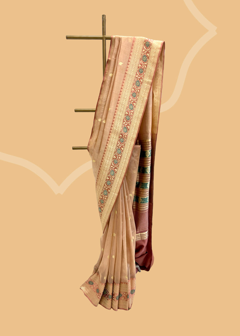 A blush pink tissue woven saree with small woven zari booties and a beautiful intricate meenakari border and pallu in soft rose pink satin fabric. Shop the best collection of authentic, handwoven, pure benarasi sarees with Roliana New Delhi