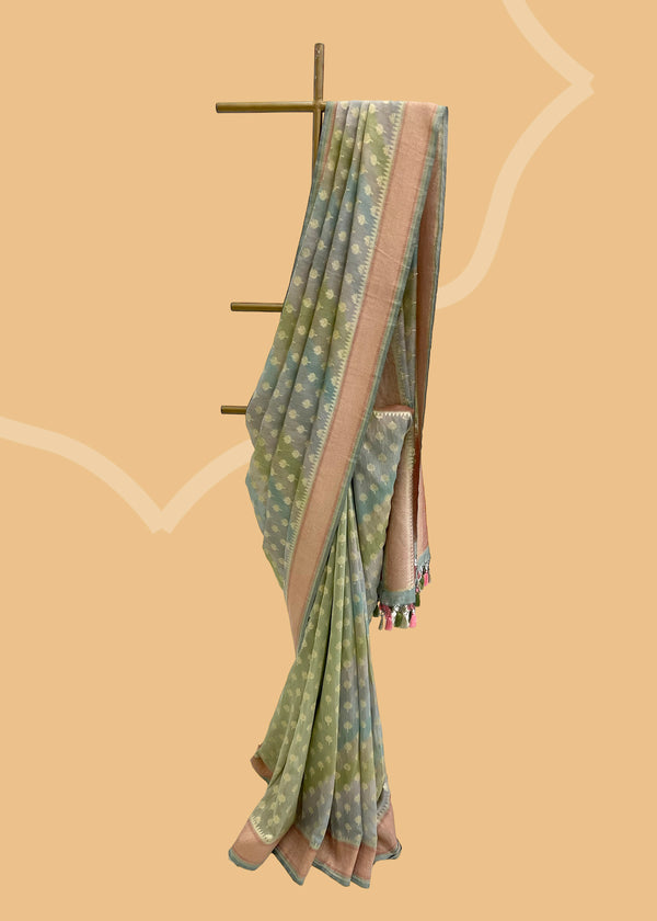 A soft silk tissue bootidar saree with hand painted aarhi stripes in colour of soft blue and green combination and a rose pink border. Shop the best collection of authentic, handwoven, pure benarasi sarees with Roliana New Delhi