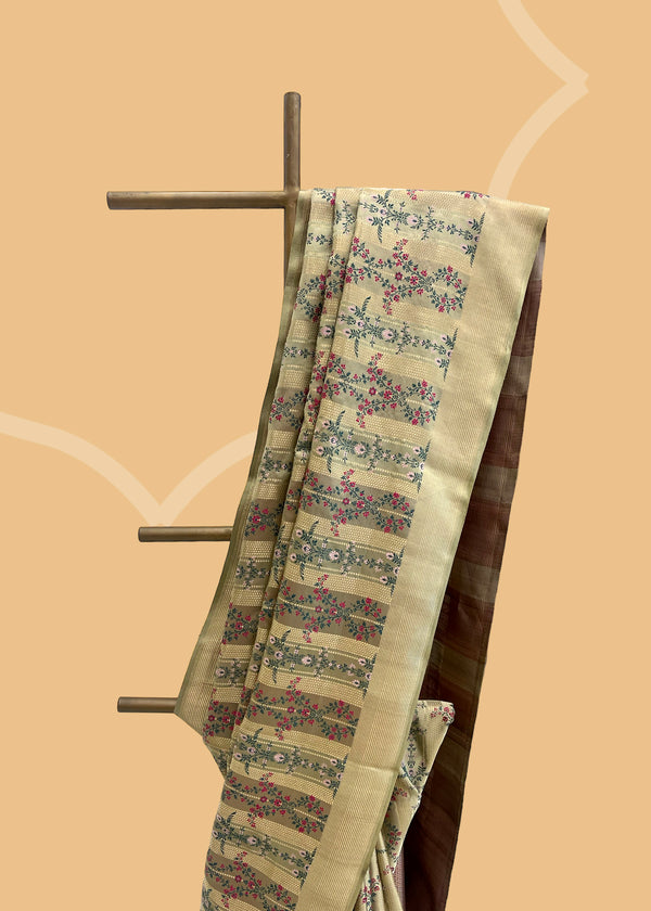 This unique and stylish Ivory & Moss Green Tanchoi Silk Benarasi Saree from Roliana is crafted with an exquisite combination of tanchoi weave and delicate, pink bunches of small flowers.