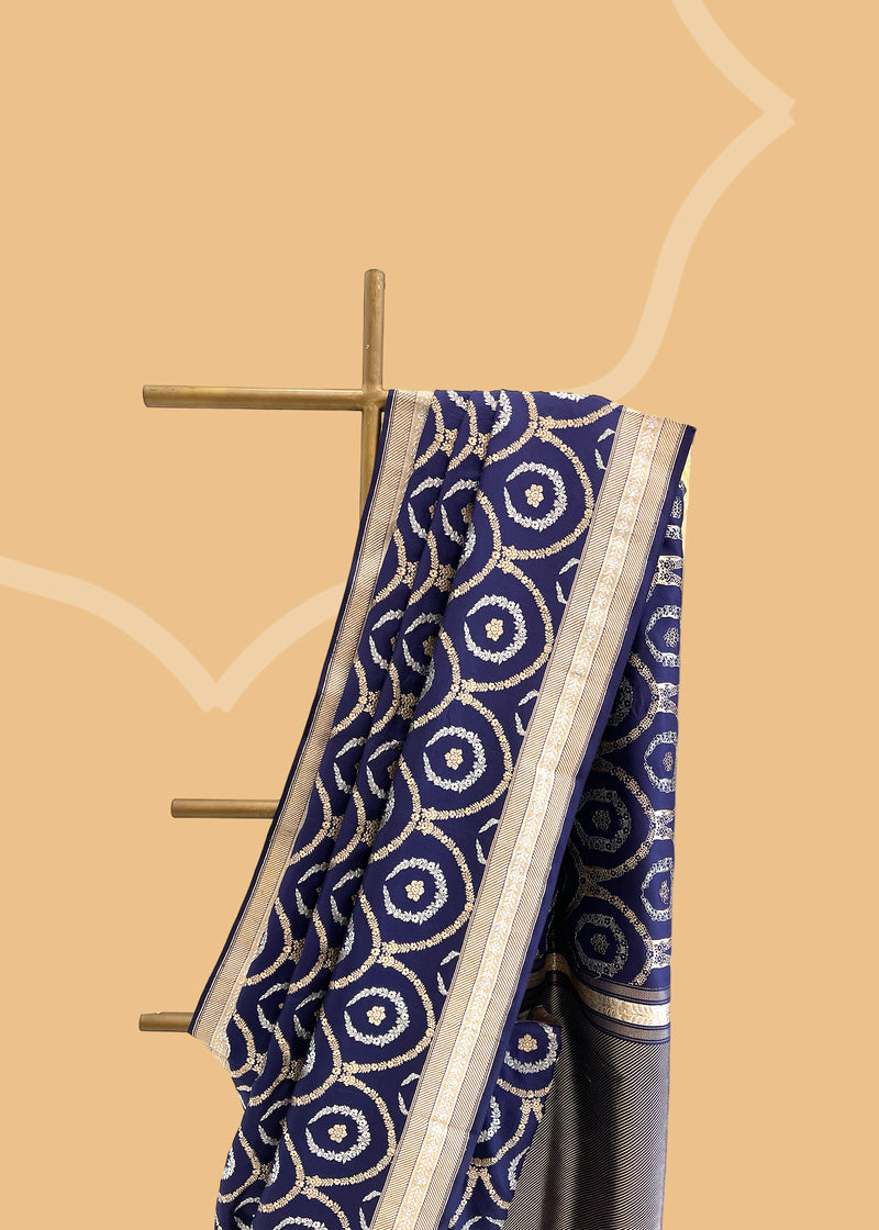 This Ink Blue Pure Silk Benarasi Saree is crafted from pure soft silk and handwoven with intricate trellis kangoora jaal in gold and silver zari..  Shop the best collection of authentic, handwoven, pure benarasi sarees with Roliana New Delhi