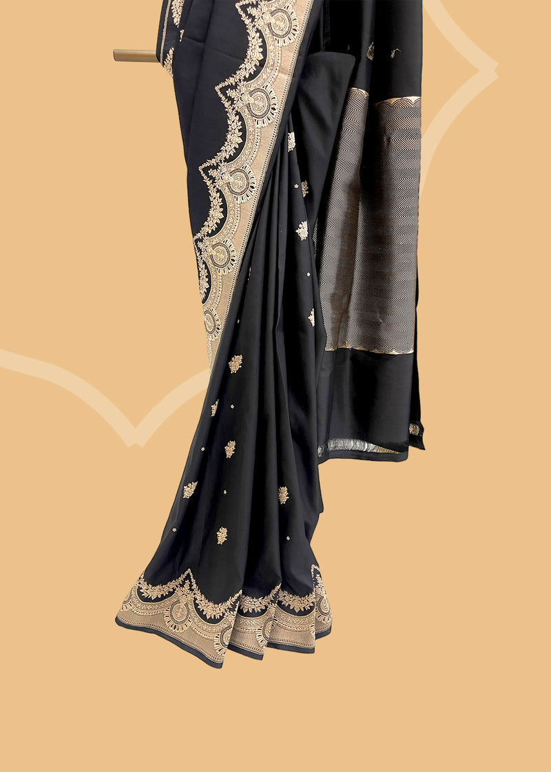 An elegant black mashru silk saree with delicate woven zari bootas and kangoora border and pallu. Shop the best collection of authentic, handwoven, pure benarasi sarees with Roliana New Delhi