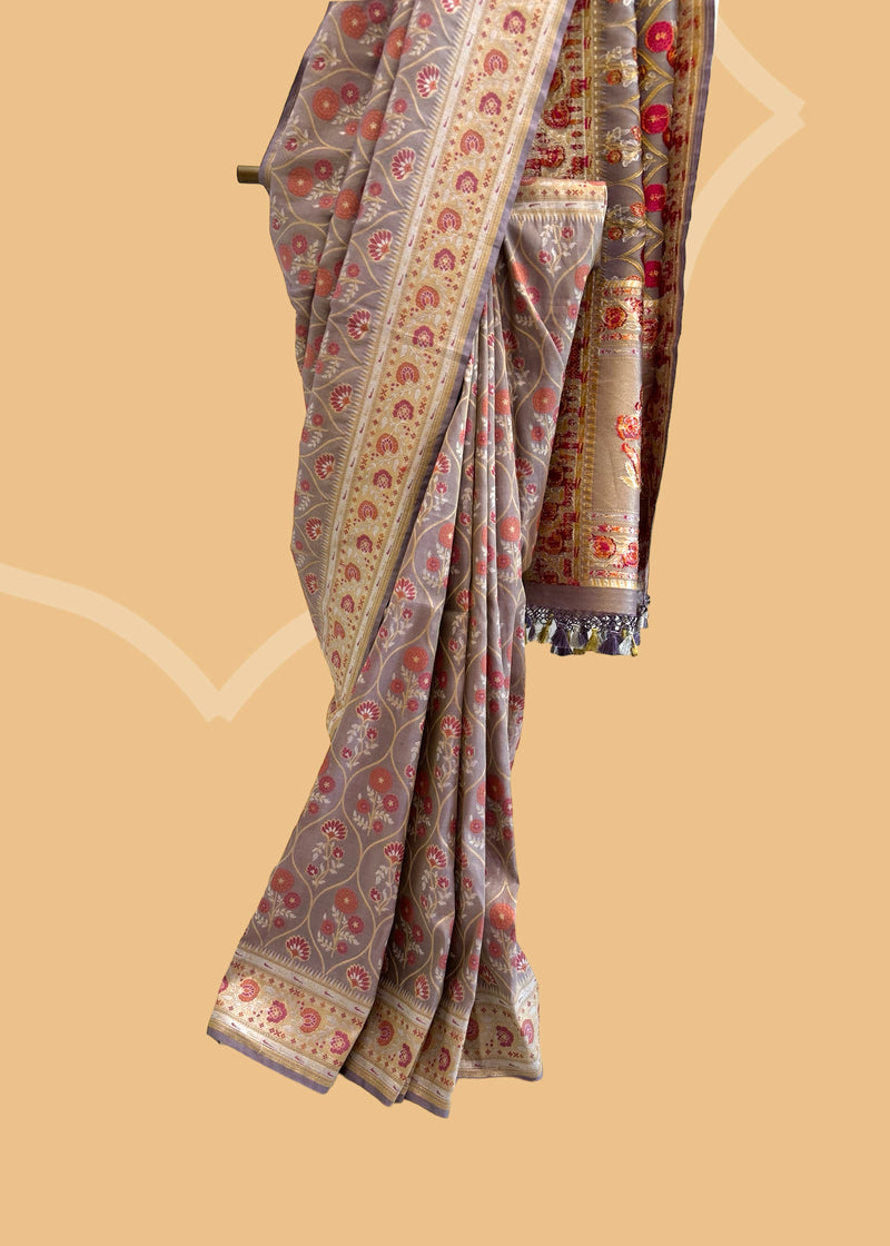 A lavender tissue by silk saree with a mehraab Meenakari design all over the body and border in zari and contrast maroon colour. Shop the best collection of authentic, handwoven, pure benarasi sarees with Roliana New Delhi