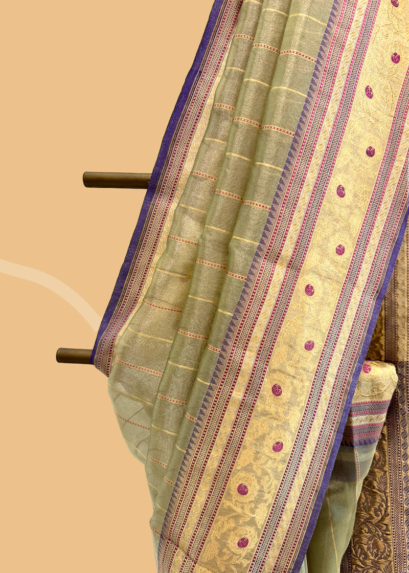 This benarasi handwoven cream saree features subtle gold bootis and a champagne shot color, complemented by a bright blue kanni and pallu. perfect for summer wedddings. Shop the best collection of authentic, handwoven, pure benarasi sarees with Roliana New Delhi