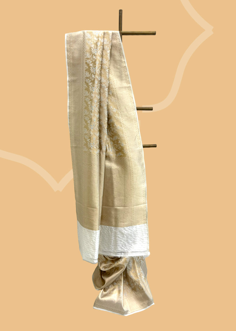 A golden tissue and cream silk saree with a beautiful woven inlay jaal with meenakari detailing all over. Shop the best collection of authentic, handwoven, pure benarasi sarees with Roliana New Delhi