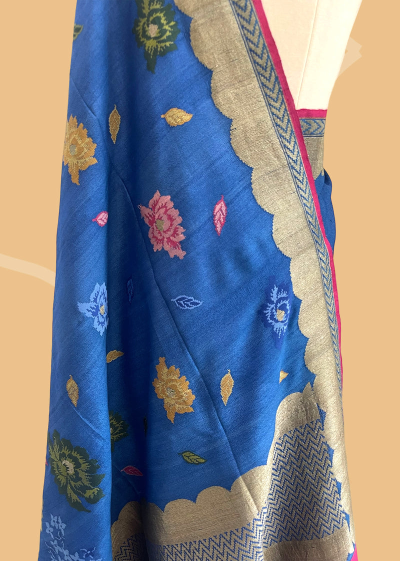 An electric blue Tussar Georgette saree by Roliana. Intricately handwoven with a beautiful contrast pink brocade blouse. Perfect for wedding and trousseau saree Shop the best collection of authentic, handwoven, pure benarasi sarees with Roliana New Delhi