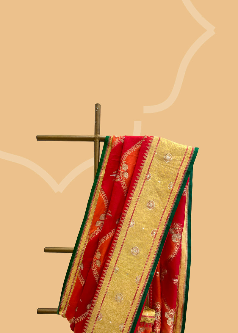 A pure ektaara silk weave saree with hand painted lehar jaal work in sunset red shades with a beautiful gold border and a bright emerald green contrast kanni . Shop the best collection of authentic, handwoven, pure benarasi sarees with Roliana New Delhi
