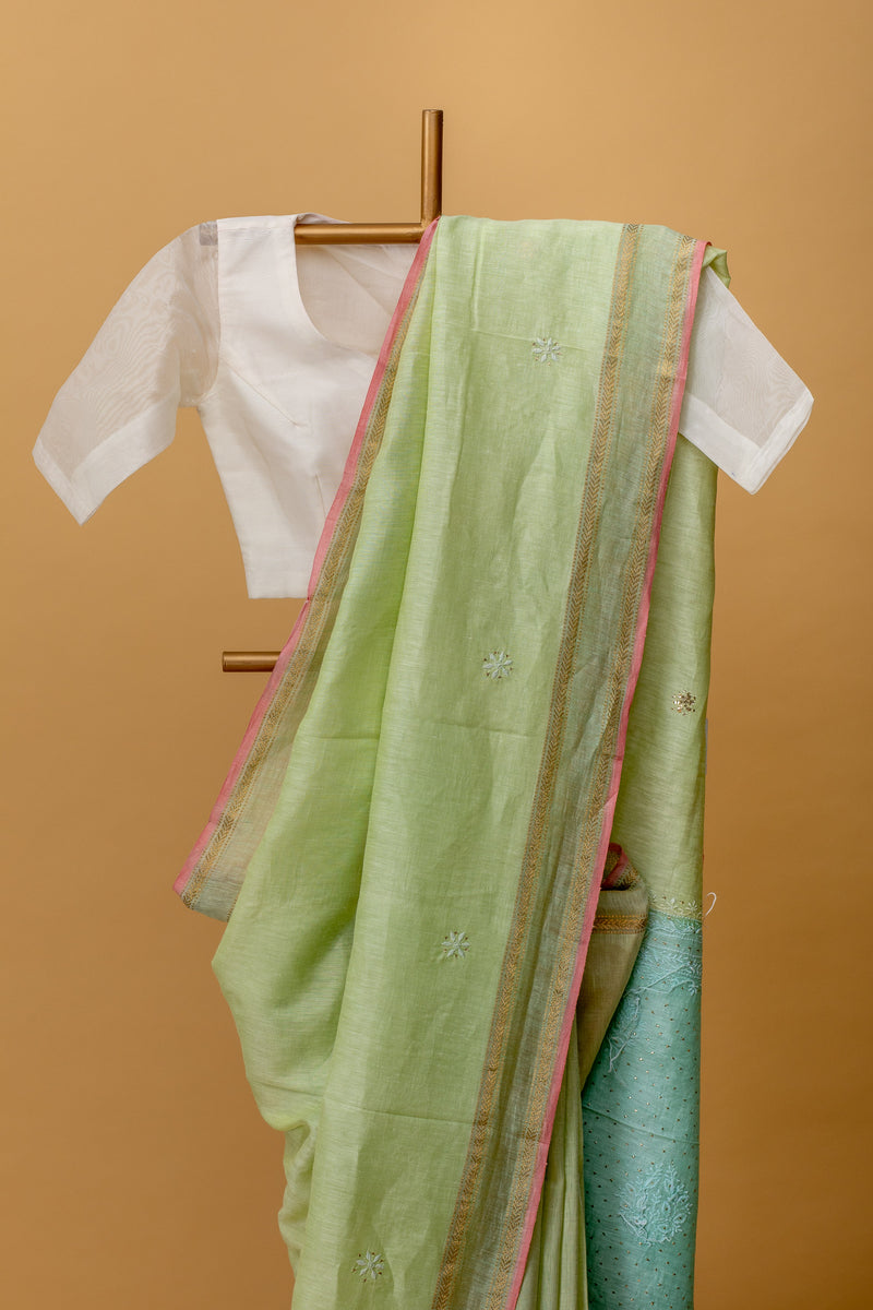 Pista green pure linen saree with delicate Chikankari bootis and pita kaamdani work by Roliana Weaves. Shop exclusive collection of hand crafted sarees by Roliana Banaras. Ekaya, Tifli