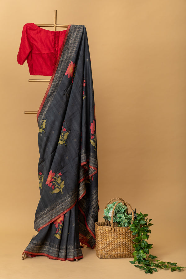 Charcoal black handwoven tussar georgette saree with silver zari bootas and handpainted red flower motifs by Roliana Weaves. Shop exclusive pure handwoven banarasi sarees at our online shop.