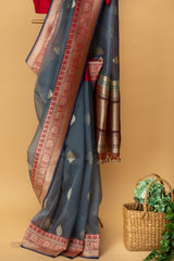 Gray handwoven pure benarasi kora silk saree with zari bootis and a contrast red zari border by Roliana Weaves. Shop exclusive sarees at Roliana online store.