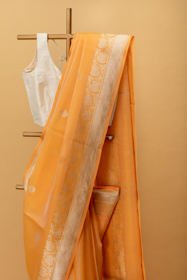 Orange pure kora handwoven banarasi saree with delicate woven bootis and floral border by Roliana Weaves.