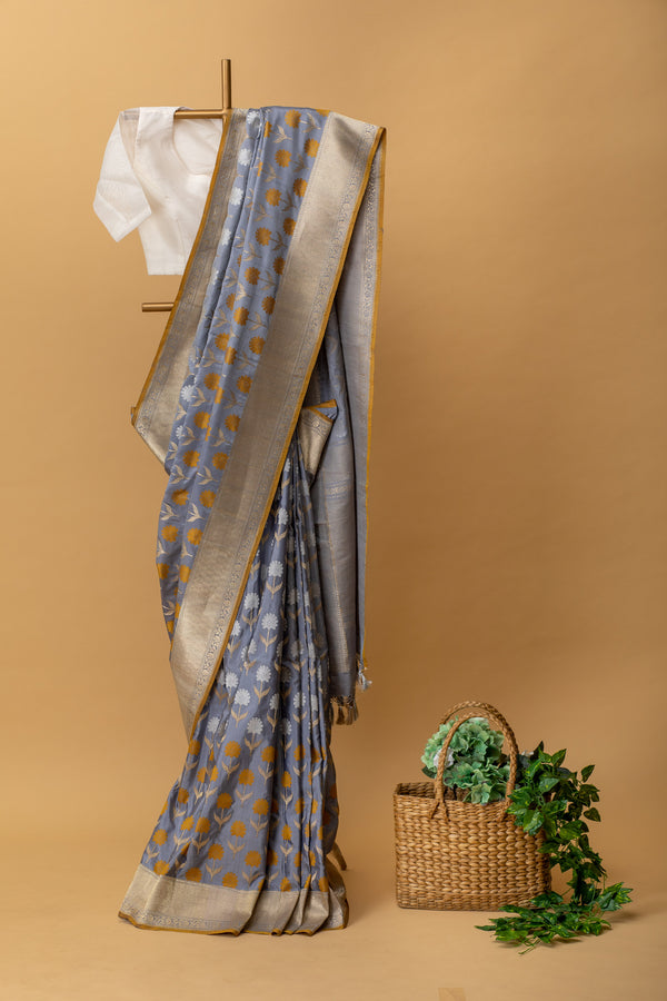 Gray pure benarasi silk handwoven saree with fun floral bootas in silver and bronze zari and a mustard kanni by Roliana Weaves. Best Banarasi Sarees online